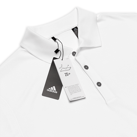 A detailed close-up of a polo shirt, showing the Adidas tags attached.