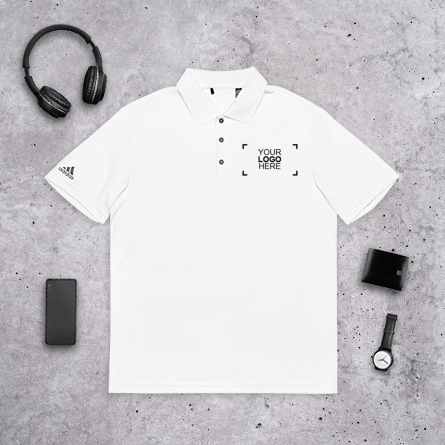 A personalized polo shirt paired with trendy accessories, such as headphones, a wristwatch, a wallet, and a phone.
